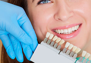 Woman smiling next to a teeth whitening 